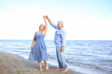 Happy mature couple dancing at sea resort