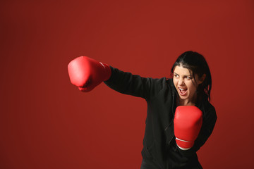 Sporty female boxer on color background