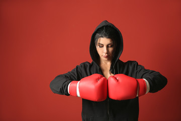 Sporty female boxer on color background