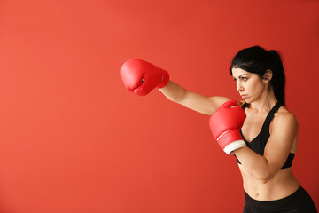 Sporty female boxer on color background