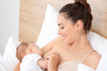 Young woman breastfeeding her baby at home