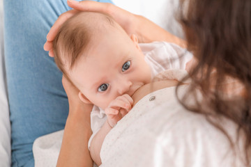 Young woman breastfeeding her baby at home