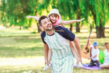 Obraz premium Little girl with her father having fun in park on summer day