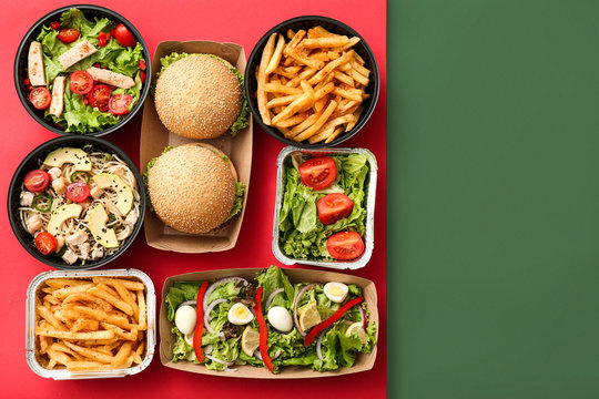 Containers with delicious food on color background