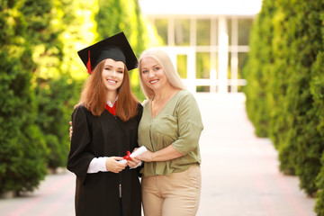 Happy young woman with her mother on graduation day