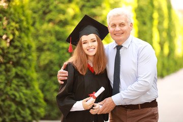 Happy young woman with her father on graduation day