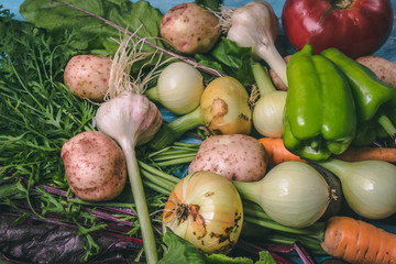 Tomato, cabbage, onion, potato, pepper, garlic, carrot and beetroot. Vegetables in a basket on a blue background. Copy space. Healthy food.