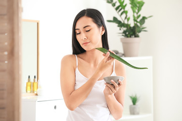Obraz na płótnie Canvas Beautiful Asian woman using aloe vera at home
