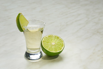 Shot of tequila on light background