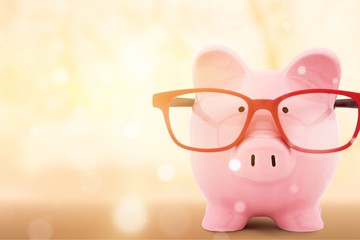 Piggy bank in red glasses on white background