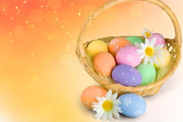 Easter basket filled with colorful eggs on a white background