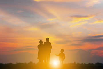 Fototapeta na wymiar Silhouette of Grandfather grandmother and grandchild playing and walking evening sunset background, Happy family concept