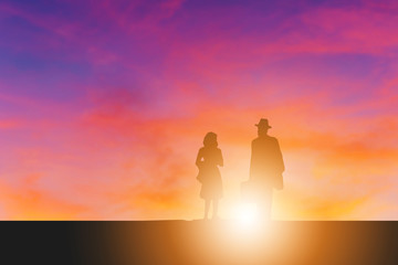 Silhouette of businessman and his wife evening sunset background