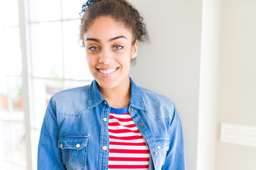 Beautiful young african american woman with afro hair wearing casual sweater with a happy and cool smile on face. Lucky person.