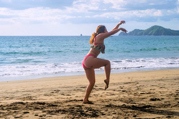 young woman jumping on the beach