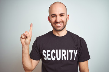 Young safeguard man wearing security uniform over isolated background showing and pointing up with...