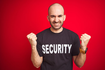 Young safeguard man wearing security uniform over red isolated background celebrating surprised and...