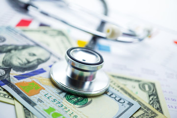 Stethoscope and US dollar banknotes on chart or graph paper, Financial, account, statistics and...