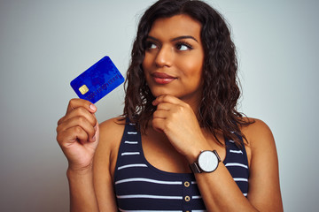 Transsexual transgender customer woman holding credit card over isolated white background serious...