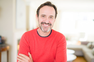 Handsome middle age man smiling looking at the camera at home