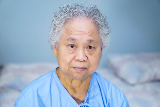 Asian senior or elderly old lady woman patient bright face while sitting in  nursing hospital ward, healthy strong medical concept. Stock Photo