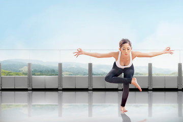 Fototapeta na wymiar Asian healthy woman practicing yoga on the terrace