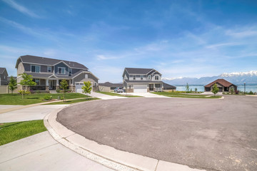 Peaceful neighborhood with scenic view of lake and mountain under blue sky