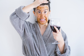 Beautiful woman wearing cosmetic facial mask as skincare treatment drinking glass of wine stressed...
