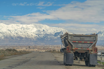 Road and industrial vehicle with valley and snow capped mountain background