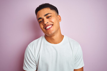 Young brazilian man wearing t-shirt standing over isolated pink background with a happy face standing and smiling with a confident smile showing teeth