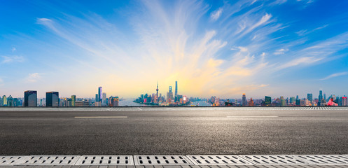 Naklejka premium Empty asphalt highway and modern city skyline in Shanghai at sunset,China