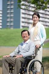 車いすで散歩するシニア夫婦