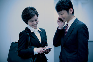 スマートフォンを持つビジネスマンとビジネスウーマン