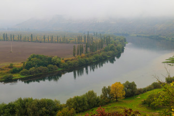 View of the Dniester river covered with a thick morning mist in autumn time