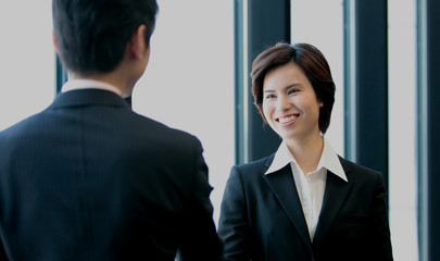 握手するビジネスマンとビジネスウーマン