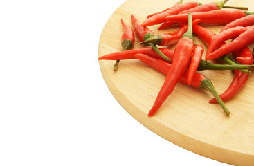 Red hot chili peppers on wooden cutting board isolated on white