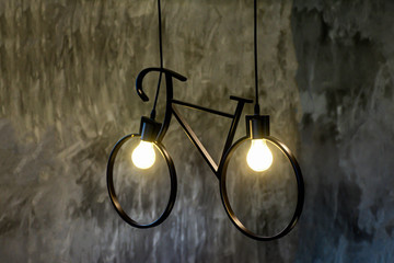 Neon lamp shine on concrete wall with copy space, Shining lamp on brick concrete wall of home, Bulb of light shape as bicycle for energy concept