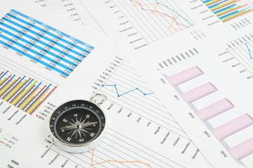 Navigation in financial world, compass on financial charts and graphs