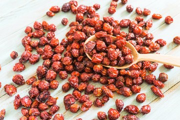 Dried dog rose fruit (Rosa canina) in a wooden spoon