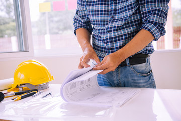 architect man reading with blueprint to build houses. After agreeing the employment price the cost...