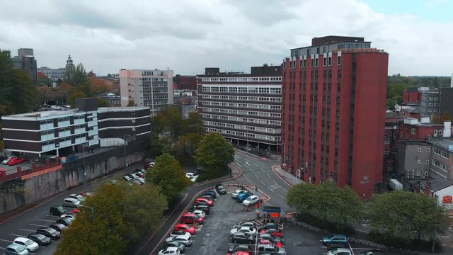 Short drone footage dipping and rising above some office buildings in Stockport.