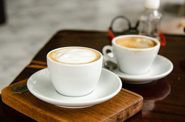 Capuchino hot coffee in white cup.