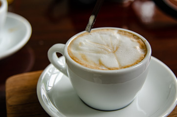 Capuchino hot coffee in white cup.