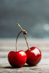Ripe and juicy cherries on the dark rustic background. Selective focus. Shallow depth of field. © maxandrew