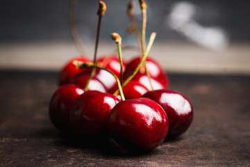 Ripe and juicy cherries on the dark rustic background. Selective focus. Shallow depth of field.
