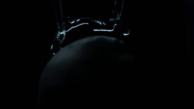 vfx plate shot of water spill drops on black sphere head and background v11