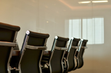 Low angle shot of chairs in a board room in a modern office with white board. The white walls and modern look makes this a perfect place to showcase corporate setup