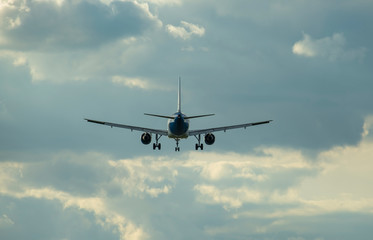 Airplane flying in the clouds in the blue sky.