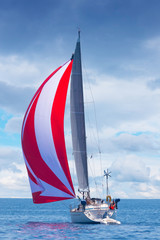holiday sailboat with red and white spinnaker sail, Adriatic sea, Croatia