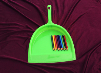 colorful pencil in green plastic sup on violet background